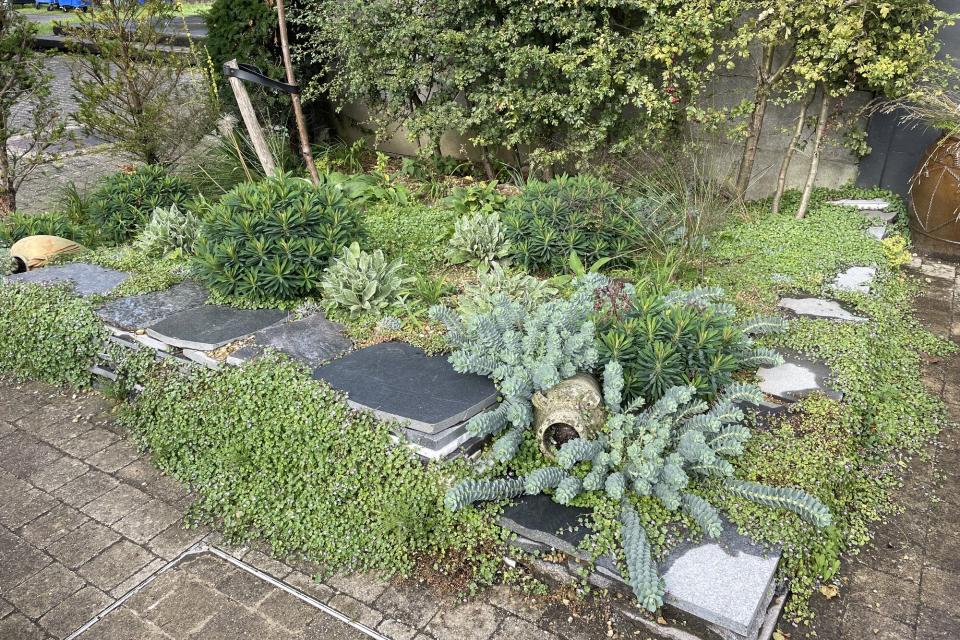 Grindtuintje als inkom van de 'Romeinse Tuin'  aangelegd met uitsluitend recuperatiemateriaal: grind van de buurman, marmeroverschotten van een steenhouwer,...